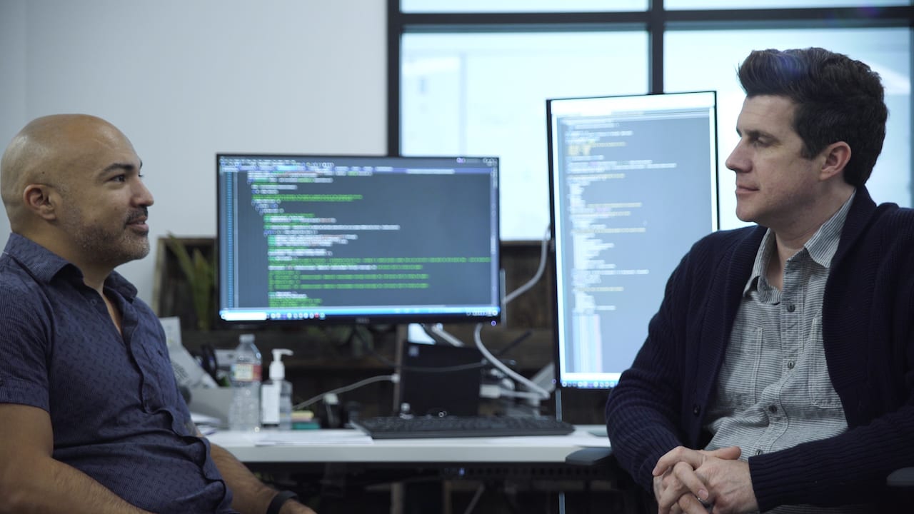 Shawn Livermore reviewing database architecture and data integration design with a colleague